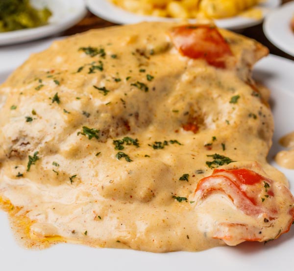 Indulge in our Alfredo tilapia, featuring flaky tilapia fillets topped with a rich and creamy Alfredo sauce for a deliciously decadent twist.
