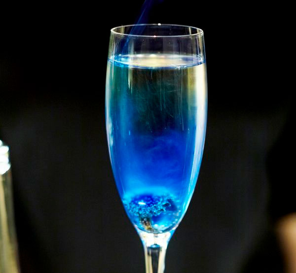 A dazzling Blue Queen cocktail made with vodka, peach schnapps, blue curaçao, simple syrup, and Sprite, creating a refreshing and visually stunning drink.