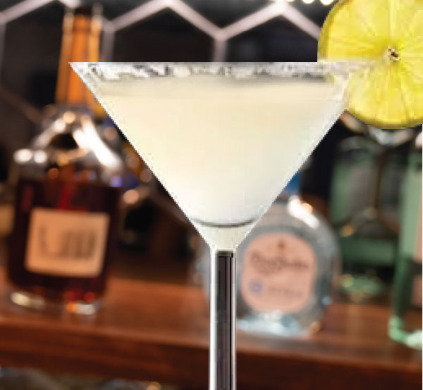 A zesty Lemon Drop cocktail made with vodka, fresh lemon juice, triple sec, lime juice, Mikki's lemonade, and simple syrup, served in a sugar-rimmed glass.