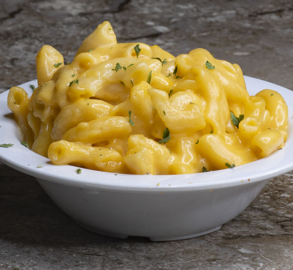 Indulge in creamy mac and cheese, a classic comfort food featuring tender pasta enveloped in a rich blend of cheeses.