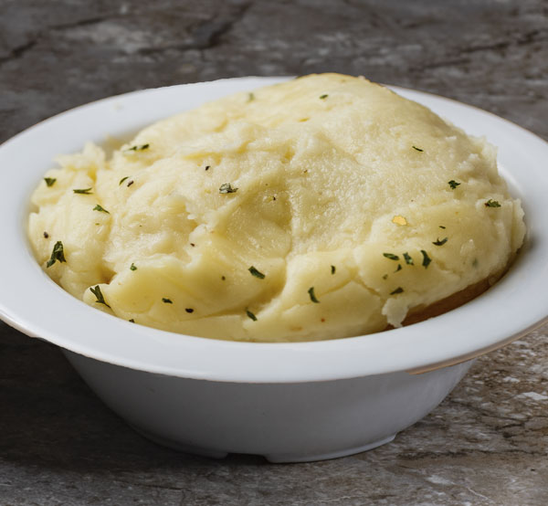 Indulge in our creamy mashed potatoes, the ultimate comfort food, whipped to perfection and ready to soak up all your favorite gravies.