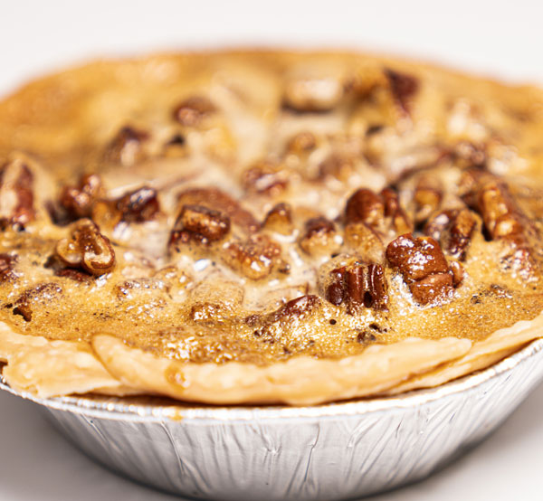 Rich pecan pie with a gooey filling and a buttery crust, offering a delightful blend of sweet and nutty flavors.