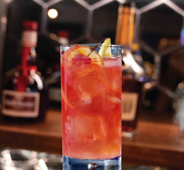 A tropical Rum Punch made with rum and a blend of tropical fruit juices, served over ice for a refreshing treat.