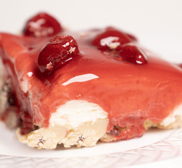 Delicious layers of strawberry cake and creamy frosting, topped with crunchy strawberry crumbles for added texture.