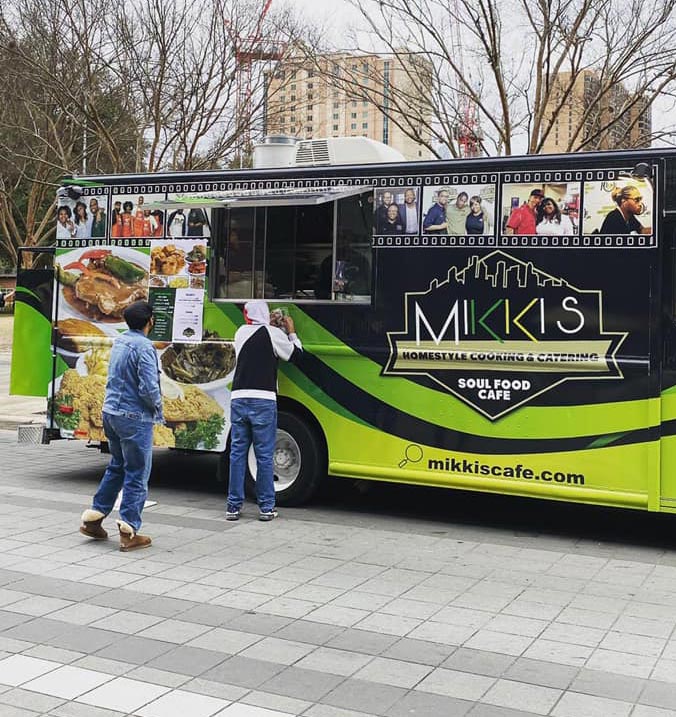 Mikki's Cafe food truck serving delicious soul food dishes to customers at an outdoor event.
